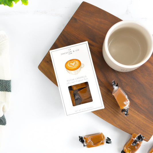 Coffeepods on a wooden tray with a coffee cup and card on a white background